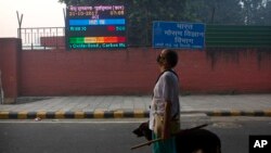 An Indian looks at the air quality level board outside India Meteorological Department, which shows condition of air as severe post during Diwali festival, in New Delhi, Oct. 20, 2017.