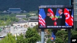 电视屏幕上显示了朝鲜领导人金正恩和美国总统特朗普的照片。（2018年11月13日）