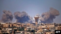 El humo se eleva por encima de las zonas controladas por los rebeldes de la ciudad de Daraa durante los ataques aéreos informados por las fuerzas del régimen sirio, el 5 de julio, 2018.
