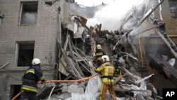 Petugas pemadam kebakaran Ukraina bekerja di sebuah bangunan yang hancur setelah serangan roket Rusia di pusat Kharkiv, Ukraina, Selasa, 6 September 2022. (Foto: AP/Andrii Marienko)