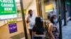 Magnolia Ortega, derecha, sale de Western Union con su esposo Arturo Morales, izquierda, y Marlene Morales, centro, después de transferir dinero a su familia en México, en el distrito de Staten Island de Nueva York, el 24 de junio de 2020.