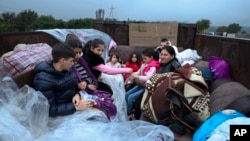 Ethnic Armenians from Nagorno-Karabakh sit in a truck on their way to Kornidzor in Syunik region, Armenia, Sept. 25, 2023. 