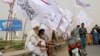 FILE - Elderly men sit under Taliban flags as Afghanistan's de facto rulers mark the second anniversary of the withdrawal of U.S.-led troops from the country, in Kandahar, south of Kabul, Aug. 15, 2023.