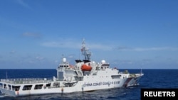 Sebuah kapal Garda Pantai China bermanuver di dekat kapal Penjaga Pantai Filipina BRP Teresa Magbanua dekat Scarborough Shoal di Laut China Selatan, Filipina, 8 Februari 2024. (Foto: via Reuters)
​