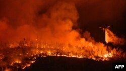 Helikopter pemadam kebakaran menjatuhkan air di atas kebakaran hutan di Oroville, California 2 Juli 2024.