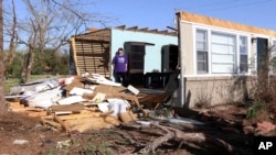 Yvonne Hayes mira la pila de escombros, el sábado 25 de marzo de 2023, después de que una tormenta derribó el techo y la pared norte de su casa la noche anterior en Amory, Misisipi. (AP Photo/Jim Lytle)