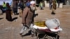 FILE - An Afghan man carries supplies in a wheelbarrow during a distribution of aid in Kabul, Feb. 16, 2022. U.S. officials, in recent talks with Taliban leaders, noted data indicating falling inflation and growing trade in Afghanistan in 2023.