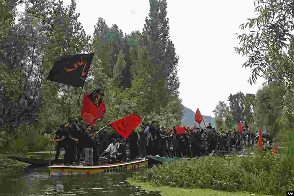 بھارت کے زیر انتظام کشمیر کی ڈل جھیل پر کشتیوں میں بیٹھ کر لوگ جلوس نکال رہے ہیں۔ 