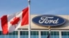 FILE - Bendera Kanada berkibar tertiup angin di dekat logo Ford di kantor pusat pembuat mobil tersebut di Dearborn, Michigan, 26 Oktober 2009. 