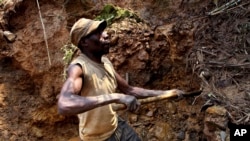 FILE - A miner digs out soil that will be filtered for traces of cassiterite, the major ore of tin, at a mine in eastern Congo, on Aug. 17, 2012. Violence has plagued the mineral-rich region, resulting in a suspension of mining ordered on July 19, 2024.