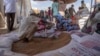 FILE - Refugees collect food rations from USAID at a distribution point in eastern Sudan, March 24, 2021. 