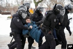 Polisi menahan seorang pria yang ingin memberi penghormatan untuk Alexey Navalny di St. Petersburg, Rusia, 17 Februari 2024. (Foto: AP Photo)
