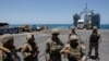 Sejumlah tentara AS berdiri di atas Dermaga Trident, dermaga sementara yang digunakan untuk mengirimkan bantuan masuk ke Jalur Gaza, di pesisir Gaza, pada 25 Juni 2024. (Foto: Reuters/Amir Cohen)