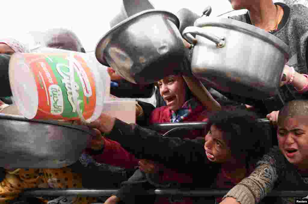 Palestinian children wait to receive food cooked by a charity kitchen amid shortages of food supplies in Rafah in the southern Gaza Strip, Feb. 13, 2024, as the ongoing conflict between Israel and the Palestinian Islamist group Hamas continues.
