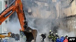 Waokoaji wakifukua kufusi cha jumba lililoharibiwa huko Uman, Cherkasy Oblast, iliyoko katikati ya Ukraine, Aprili 28, 2023, baada ya makombora ya Russia kupiga miji kadhaa ya Ukraine usiku kucha. 