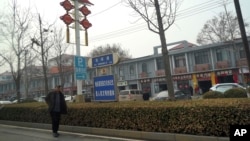 FILE - A man walks along the road in the city of Handan in northern China's Hebei province on Feb. 28, 2024. 
