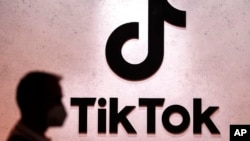 Seorang pengunjung berjalan melewati logo TikTok yang terpasang pada sebuah stan dalam pameran gim komputer Gamescom di Cologne, Jerman, pada 25 Agustus 2022. (Foto: AP/Martin Meissner)