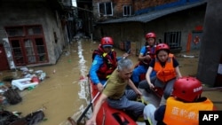 Tim evakuasi membantu sejumlah warga di area yang terdampak banjir di Nanping, China, pada 16 Juni 2024. (Foto: CNS/AFP)