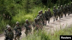 FILE - Japan Ground Self Defense Force members take part in a joint exercise with U.S. Marines on the northern island of Hokkaido, Japan, Aug. 16, 2017. Japan plans to hold joint military exercises with Germany and Spain on the island in June 2024.