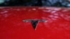 Logo Tesla terpasang pada kendaraan yang ditampilkan di sebuah acara di Austin, Texas, pada 22 Februari 2023. (Foto: AP/Eric Gay)