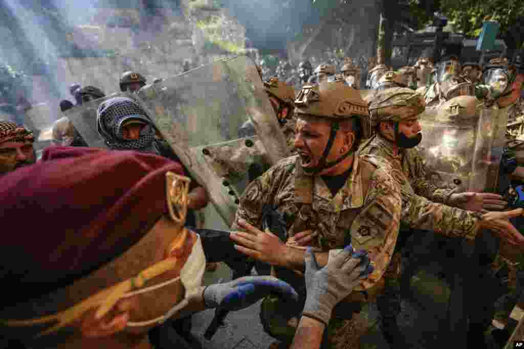 Retired members of the Lebanese security forces and other protesters scuffle with Lebanese army after they removed a barbed-wire barrier in order to advance towards government buildings during a protest in Beirut, April 18, 2023.