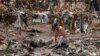 Seorang pria mencuci pakaiannya di sungai setelah air banjir meluluhlantahkan Desa Nanxinfang di pinggiran Beijing, Jumat, 4 Agustus 2023. (Foto: AP)