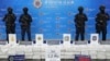 Police officers stand behind seized crystal methamphetamine during a news conference in Bangkok, Thailand, May 29, 2023.