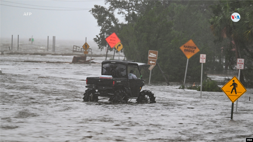 Personas circulan por una calle inundada cerca del puerto deportivo de Steinhatchee, en Steinhatchee, Florida, después del paso del huracán Idalia el 30 de agosto de 2023. 