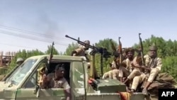 FILE - Fighters ride in the back of a pickup truck mounted with a turret in the East Nile district of greater Khartoum, in this image grab taken from handout video footage released by the Sudanese paramilitary Rapid Support Forces on April 23, 2023.