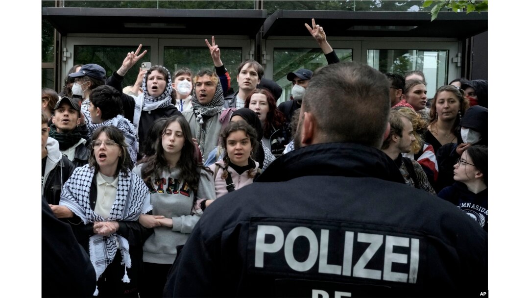 Protesters face German police officers during a pro-Palestinians demonstration by the group "Student Coalition Berlin" at the 'Freie Universität Berlin' in Berlin, Germany, Tuesday, May 7, 2024. (AP Photo/Markus Schreiber)