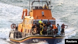 Rescue personnel bring migrants ashore after their boat sunk in the English Channel, near Dover, Britain, Aug. 12, 2023, in this photo obtained from social media. (Stuart Brock/via Reuters)