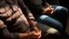 ARCHIVO - Dos hombres esposados que presuntamente forman parte de una red de trata de personas esperan que comience una audiencia en los tribunales de justicia de la ciudad de Guatemala, el 4 de febrero de 2022.