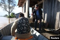 Warga dievakuasi dengan perahu saat meninggalkan rumah mereka yang terendam banjir di Venancio Aires, negara bagian Rio Grande do Sul, Brazil, 5 September 2023.
