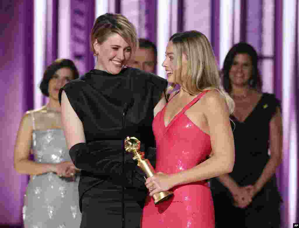 This image released by CBS shows co-director Greta Gerwig, left, and actor Margot Robbie accepting the award for best cinematic and box office achievement for the film "Barbie" during the 81st Annual Golden Globe Awards in Beverly Hills, Calif., on Sunday, Jan. 7, 2024.