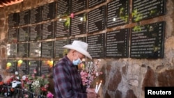 Un hombre coloca velas en un memorial durante una ceremonia para conmemorar el 40 aniversario de la masacre de El Mozote, en el pueblo del Mozote, en Meanguera, El Salvador, el 11 de diciembre de 2021.