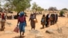 Sudanese refugees who have fled the violence in their country, wait in line to receive food from World Food Program, near the border between Sudan and Chad in Koufroun, Chad, May 9, 2023. 