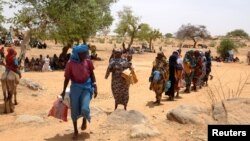 Sudanese refugees who have fled the violence in their country, wait in line to receive food from World Food Program, near the border between Sudan and Chad in Koufroun, Chad, May 9, 2023. 