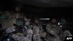 Sejumlah tentara Ukraina menaiki truk yang membawa mereka dari Chasiv Yar ke Bakhmut di Donetsk, pada 9 Maret 2023. (Foto: AFP/Sergey Shestak)