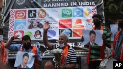 FILE - Activists of Jammu and Kashmir Dogra Front shout slogans against Chinese President Xi Jinping next to a banner showing the logos of TikTok and other Chinese apps banned in India during a protest in Jammu, India, July 1, 2020. (AP Photo/Channi Anand, File)
