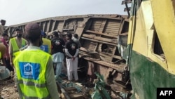 Volunteers search for the victims in the carriages following the derailment of a passenger train in Nawabshah, in the Pakistan's southern Sindh province, Aug. 6, 2023. 