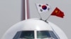 FILE - With national flags of South Korea, left, and China, a Boeing 747 arrives at Beijing Capital International Airport, June 27, 2013.