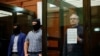 Mantan anggota marinir AS, Paul Whelan, berdiri di dalam sel terdakwa dalam sidang kasus yang menimpa dirinya di Moskow, Rusia, pada 15 Juni 2020. (Foto: Reuters/Maxim Shemetov)