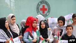 Palestinci stoje ispred kancelarije Crvenog krsta u Bejrutu u znak podrške sunarodnicima u Gazi