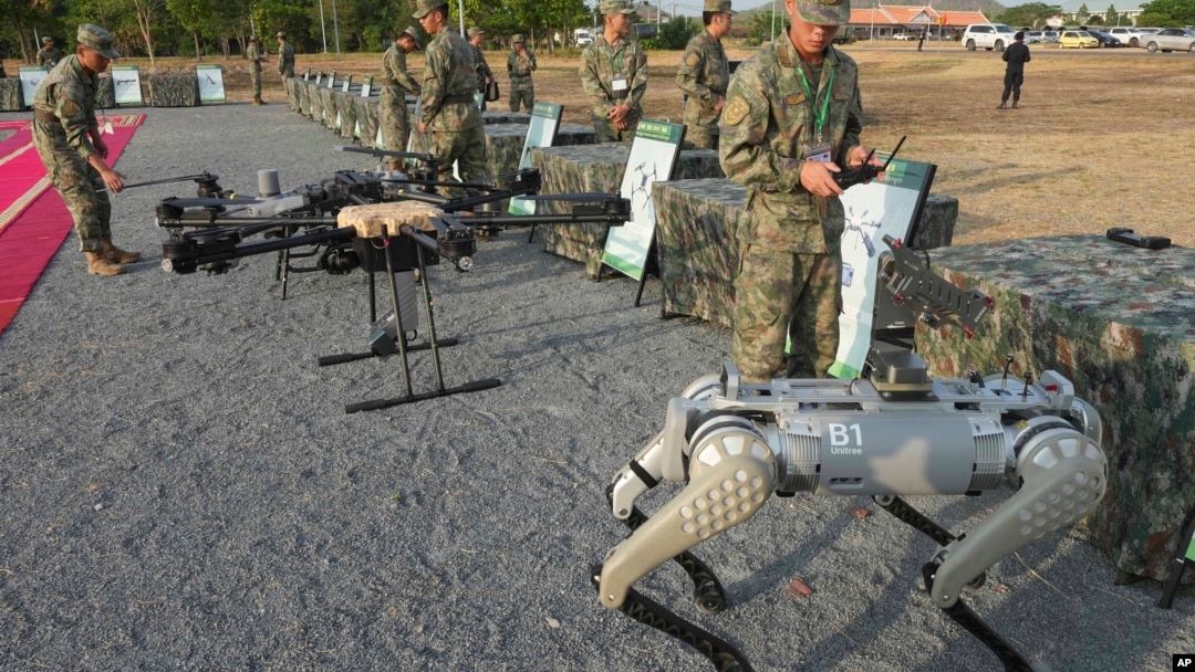 在柬埔寨金邊北部舉行的中柬「金龍」聯合軍演舉行之前，中國軍人（右）在檢驗機器狗。 （2024年5月16日）