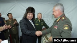 Pemimpin Korea Utara Kim Jong Un berjabat tangan dengan Menteri Pertahanan Rusia Sergei Shoigu, saat ia mengunjungi Vladivostok, Rusia, 16 September 2023. (Foto: KCNA via REUTERS)