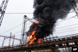 Api dan asap mengepul dari kobaran api di fasilitas listrik setelah serangan Rusia di Kharkiv, Ukraina, 22 Maret 2024. (Foto: AP)