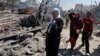 Des Palestiniens parcourent les ruines d'un camp de déplacés après une frappe israélienne à Khan Younis, dans le sud de la bande de Gaza, le 13 juillet 2024. (Reuters/Mohammed Salem)