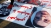 ARHIVA - Irački demonstranti hodaju preko crteža sa likom bivšeg predsednika Iraka Sadama Huseina i fotografije njegove ćerke Ragad Sadam Husein, tokom antivladinih protesta u Bagdadu, Iraj, 21. decembra 2019.
