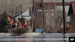 Russian Emergency Situation Ministry rescuers ride a boat to help local residents during evacuations from a flooded area in Orenburg, Russia, on April 11, 2024.