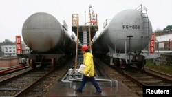 資料照片：2009年3月2日，四川省遂寧市，一名工人走過運輸油罐的火車。（路透社照片）
